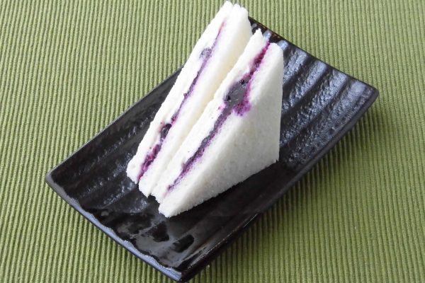 パンの間に挟まれた、ブルーベリーソースとその紫に染まったクリームチーズ。